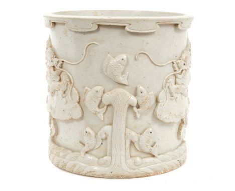 Chinese Qing blanc-de-chine brush pot decorated in relief with two five-toed dragons and jumping fish with wave moulded base 