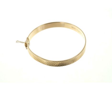 Gold (9ct) hinged bangle with engine-turned decorationCondition report: Weight approximately 14.4 grams
