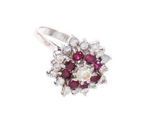 Ruby and diamond cluster cocktail ring with a central brilliant cut diamond surrounded by eight round mixed cut rubies and a 