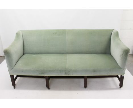 George III and later sofa, squared form, green velvet upholstery on square supports and stretchers and brass castors