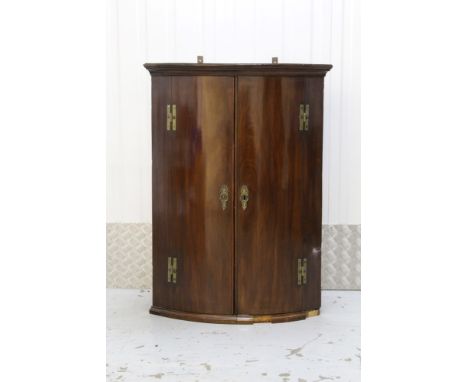 George III mahogany bow front hanging corner cupboard with painted interior enclosed by two doors with moulded cornice. 75cm 