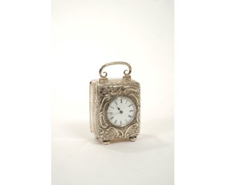 Edwardian dressing table clock with time piece movement, lever escapement and white enamel dial with Roman numerals, in a sil