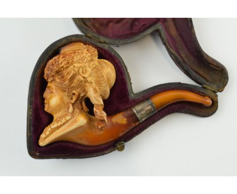 Antique meerschaum pipe with amber mouthpiece and white metal collar, with carved decoration in the form of a ladies head, in
