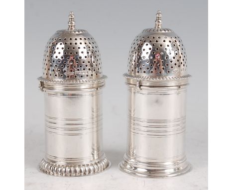 A matched pair of late Victorian silver sugar casters, each of cylindrical form, with finial topped and pierced dome covers, 