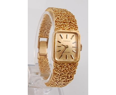 An 18ct yellow gold lady's Tissot manual wind wristwatch, the watch having a rectangular champagne baton dial with integral t