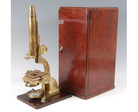 A 19th century lacquered brass monocular microscope, the single adjustable eye-piece above a square adjustable stage, with sw