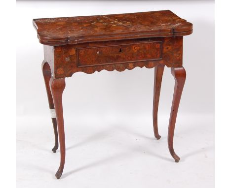 An 18th century continental walnut and marquetry inlaid card table, of small proportions, the shaped fold-over top marquetry 