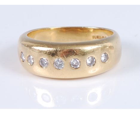 An 18ct yellow gold seven stone diamond Gypsy style dress ring, the round brilliant cut diamonds measuring between approx 2.2