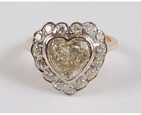 An 18ct yellow and white gold heart shaped diamond cluster ring, comprising a centre heart shaped diamond within a border of 