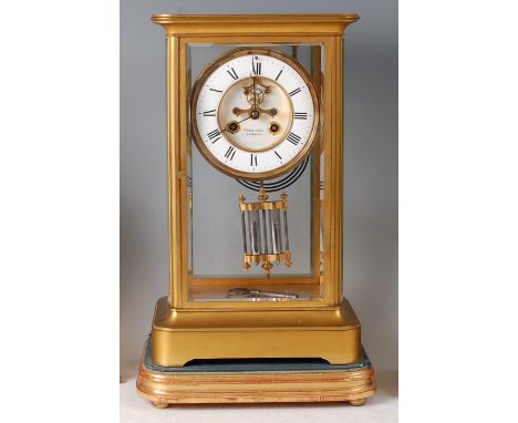 A late 19th century brass cased four glass mantel clock, having white enamel chapter ring, visible escapement, dial signed T 