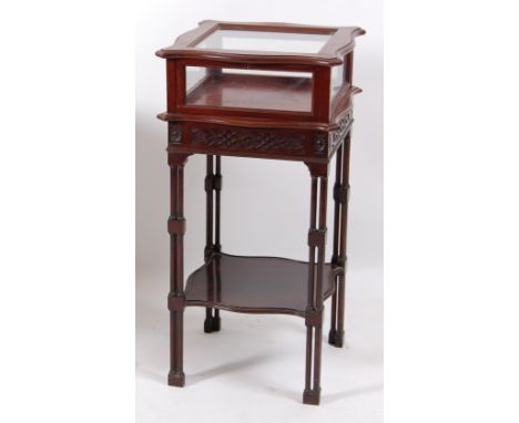 An Edwardian mahogany vitrine / display table, in the Chinese Chippendale style, the glazed top of serpentine outline over a 