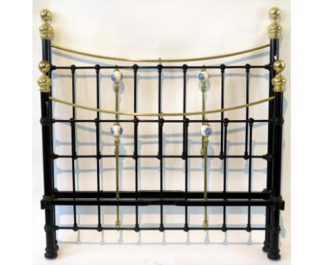 A Victorian iron and brass double bedstead 
With four ceramic knobs, height 148cm, width 136cm 