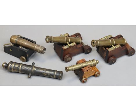 Five brass model cannon; four mounted on wooden carriages; one cannon stamped 1812.