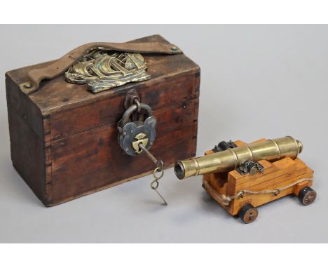 A brass naval signal cannon, barrel 22cm long, mounted on a mahogany carriage having four steel wheels, &amp; in a fitted woo