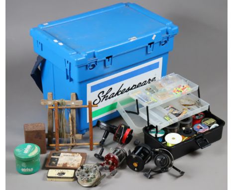 A Shakespeare blue plastic angler’s box containing various fishing reels, lures, etc.
