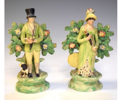 Pair of 18th/19th Staffordshire figures of a lady and gentleman hunting, with bocage background, 19cm high  