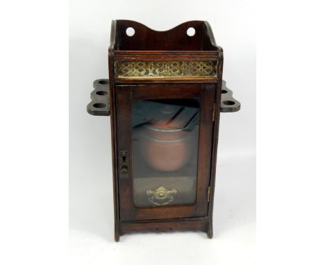 A Victorian oak smoker's cabinet, with a galleried top, folding pipe racks and a glazed door enclosing a single drawer, 18cm 