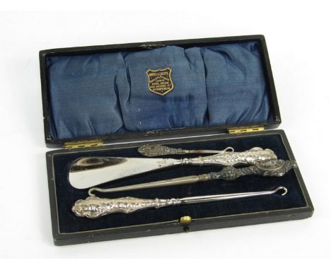 A George V silver handled button hook and shoe horn, with hammered decoration, Birmingham 1910, cased, Edward VII button hook