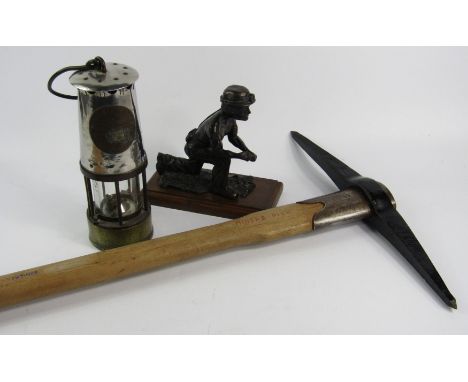 A Holdfast 2 1/2lb miner's pick axe, 81cm long, together with a miner's lamp and a cast figure of a miner, (3).