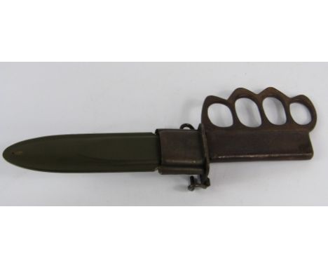 A WWII US Army combat knife, with a knuckle duster grip in an Ordnance scabbard, 29cm long.