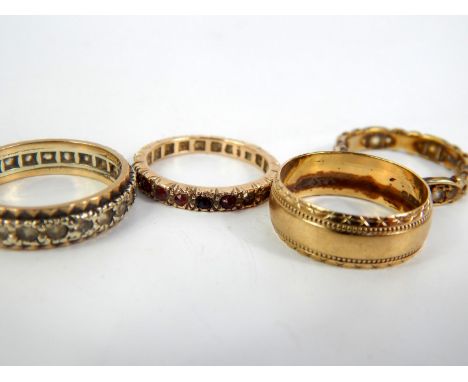 Three yellow metal and gem set eternity rings, size M, N E-R, and a 9ct gold wedding band, size N/O, 12.7g