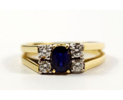 An 18ct gold sapphire and diamond ring, the central oval cut sapphire flanked by two pairs of diamonds, high claw set, sapphi