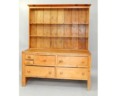 A pine dresser, with two shelf Delft rack over two small, one medium and three long drawers, raised on straight legs, 155cm x