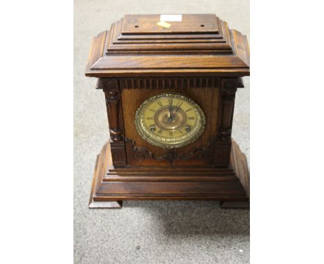 A CARVED WOODEN MANTLE CLOCK