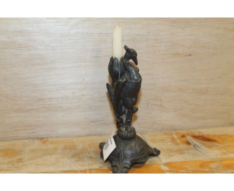 A SMALL VINTAGE METAL CANDLE HOLDER IN THE FORM OF A PHOENIX