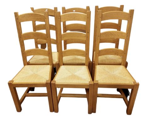 A set of six oak ladder back dining chairs with rush seats.
