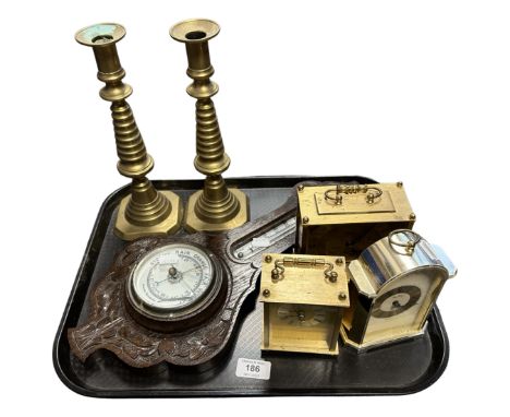 A tray containing an oak barometer (AF), a pair of brass candlesticks and three mantel clocks.
