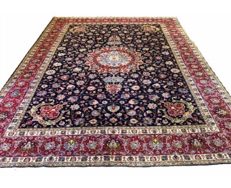 FINE PERSIAN TABRIZ CARPET, 395cm x 297cm, central medallion on a midnight blue palmette and vine field within corresponding 