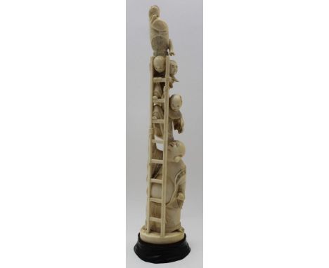 A Japanese Meiji period carved figure group, Buddha type figure supports a ladder on which children climb, 36cm high, charact