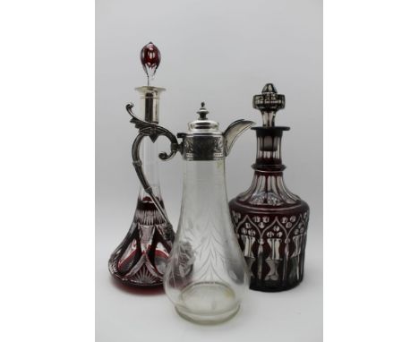 A large ruby flashed & cut decanter with stopper, together with a similar decanter fitted with silver collar & a cut glass cl