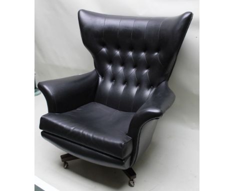 A 1970s black vinyl button backed G-plan armchair, on a four point base, with castors below, 100cm highCondition report: Seat