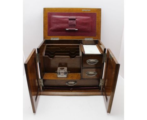 An Edwardian oak desk top stationery cabinet, hinged lid and two front doors open to reveal a fitted interior of drawers and 