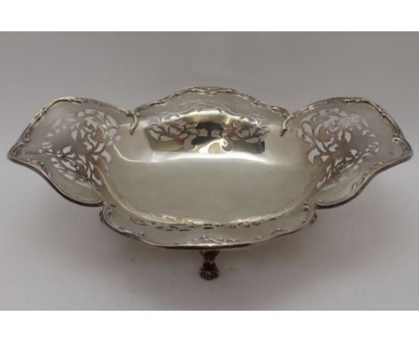 An early 20th century silver bread basket, shaped rim, pierced decoration, of oval form, raised on four scroll toe feet, Birm