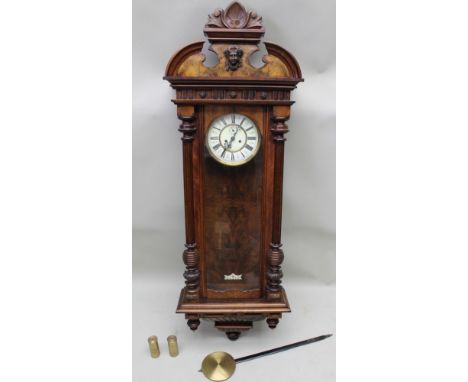 A late 19th-century Viennese style hanging wall clock, with architectural pediment between decorative plaster sconce, deglaze