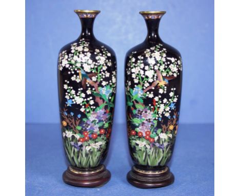 Pair boxed vintage Japanese cloisonne vases each with birds in flowers decoration, on black ground, on fitted stands. Height 
