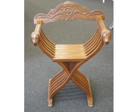 Vintage carved timber X form chair decorated with mythical animal arms and claw feet, width 66cm approx