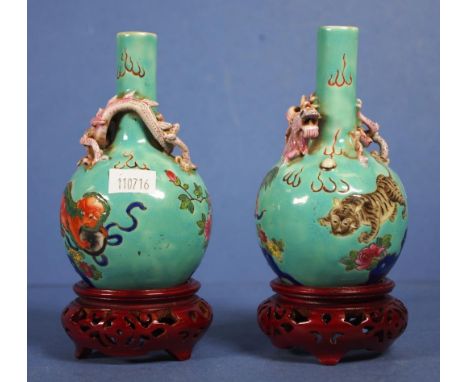Pair Chinese green ceramic posy vases applied dragon decoration, on carved wood bases. Height 12cm approx (each vase).
