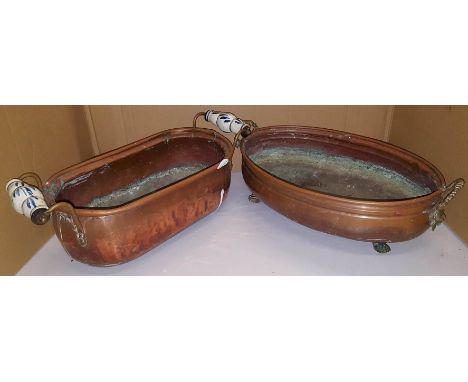 Copper planter with blue and white ceramic handle and copper planter with lion mask handles and paw feet