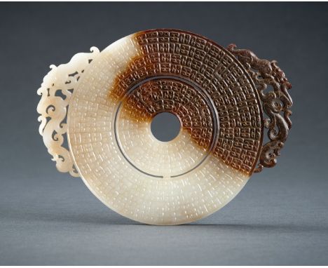 AN ARCHAISTIC WHITE AND BROWN JADE DOUBLE BI DISC, QINGChina, Qing Dynasty (1644-1912). Executed with great artistry in the E