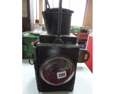 A RAILWAY HAND LAMP, removable red lens, bulls eye glass, missing reservoir and burner, has remains of candle inside, opening