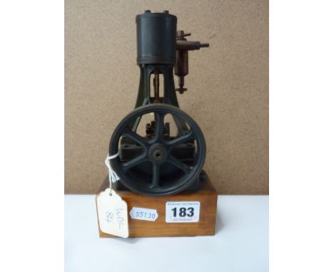 A STUART VERTICAL SINGLE CYLINDER STEAM ENGINE, not tested, driving a 7.5cm diameter flywheel, mounted on a wooden plinth, he