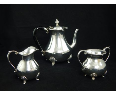 White metal three piece tea service marked "silver", with beaded rims and baluster bodies on cast floral feet, 1170 g gross