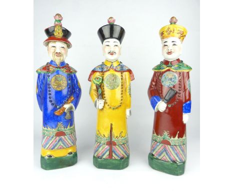 Chinese porcelain figure of a man of high rank, 36cm h, with two further similar, all with seal marks to base, (3)