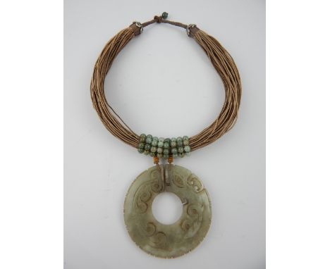 Jade necklace, the pendant in the form of a bi, on a multi-strand silk collar