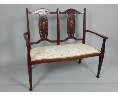 Edwardian mahogany framed twin chair back sofa, with pierced and inlaid splats above a pad upholstered seat, on square taperi