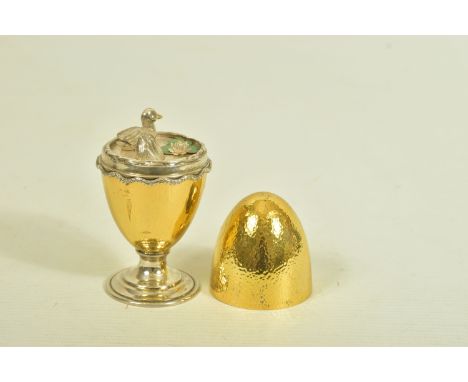 A SILVER EGG ORNAMENT, designed as a gold plated textured egg, opening to reveal a pond scene with two ducks and green enamel
